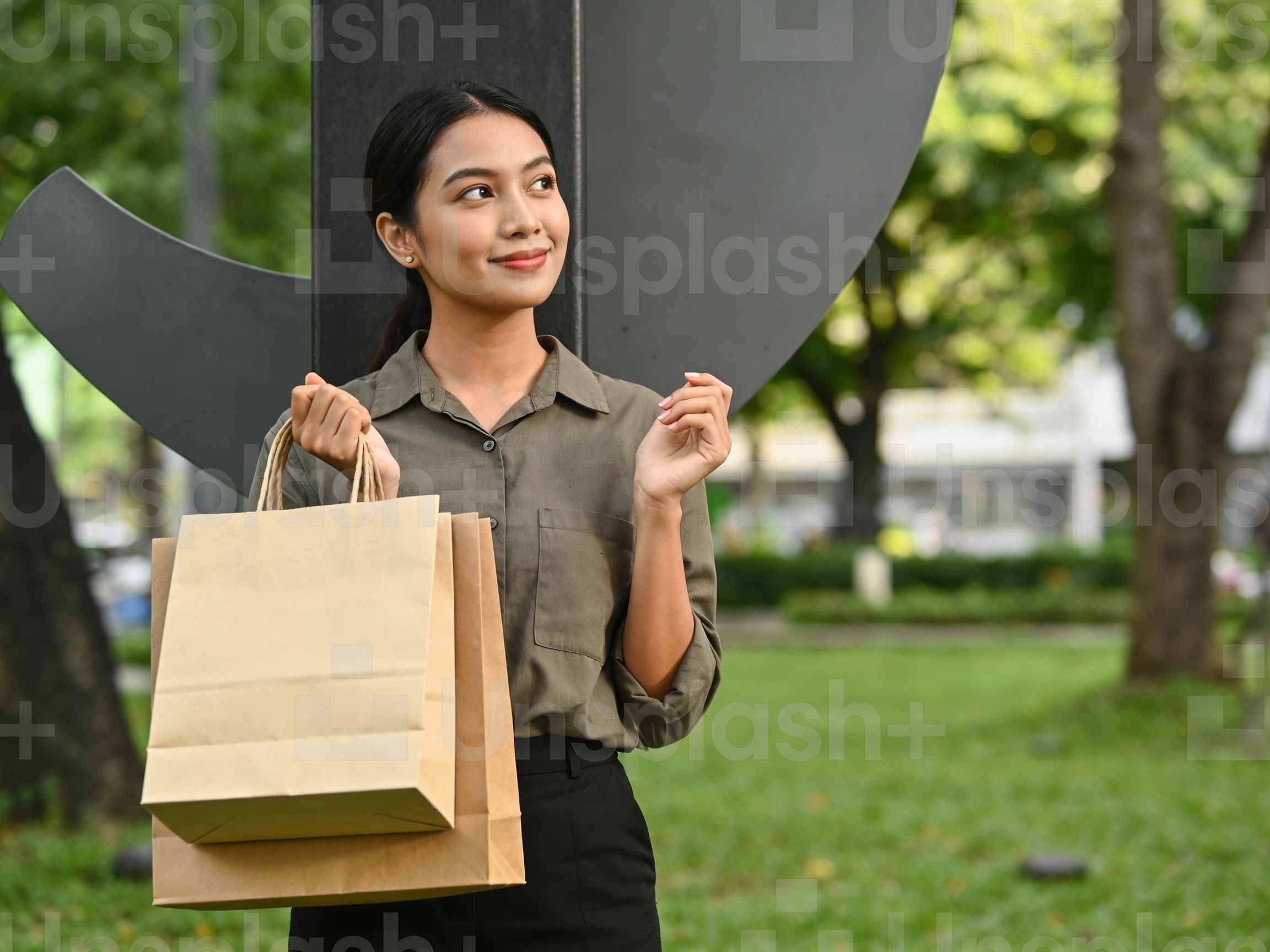Wanita Indonesia berpakaian santai memegang tas belanja di koridor The Berkshire Mall menerapkan panduan belanja di mall
